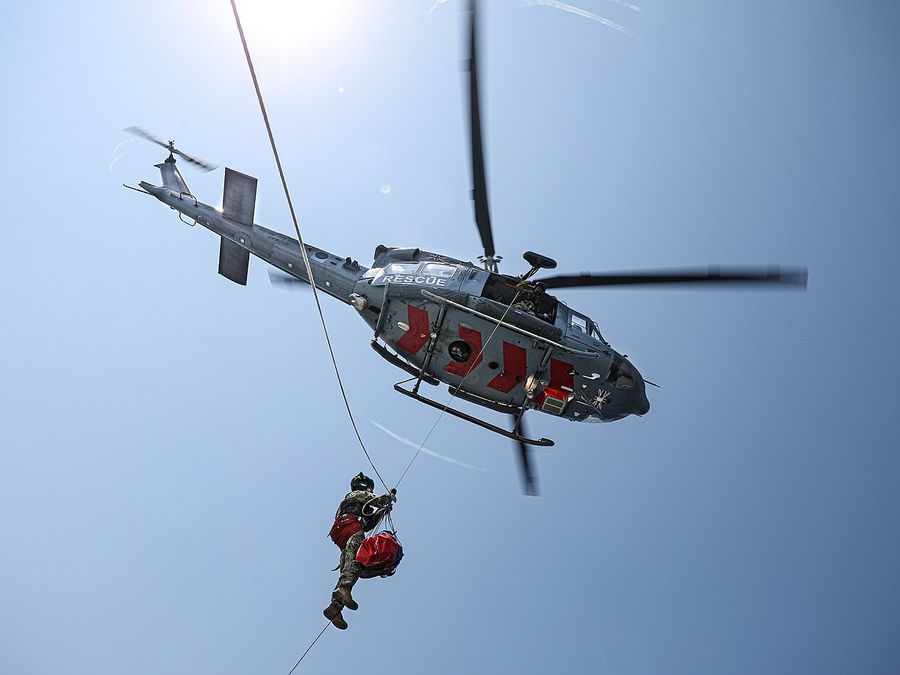 An 84 Squadron RAF helicopter winches a crewman during a medical evacuation exercise